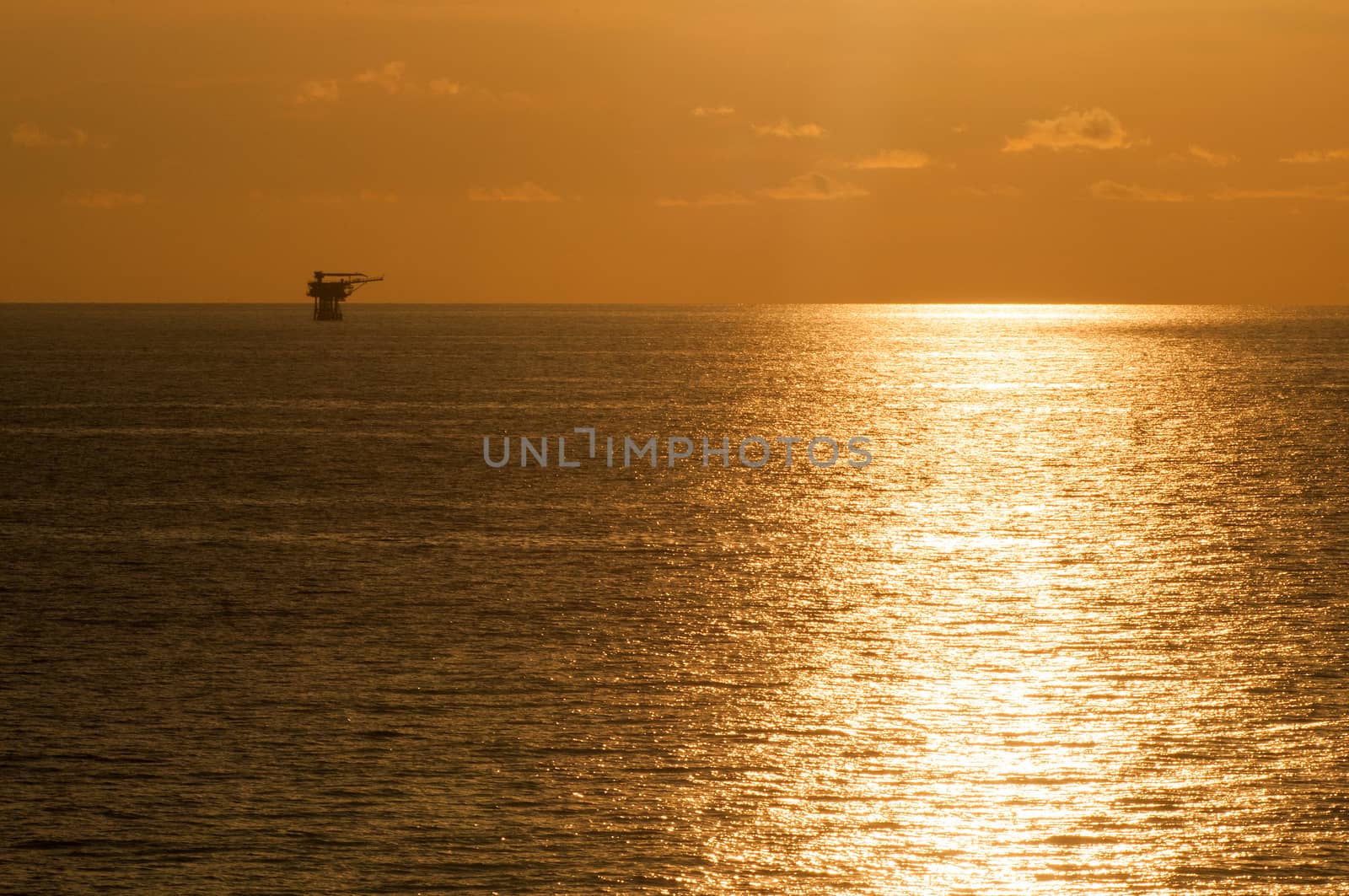 offshore rig in sunset by think4photop