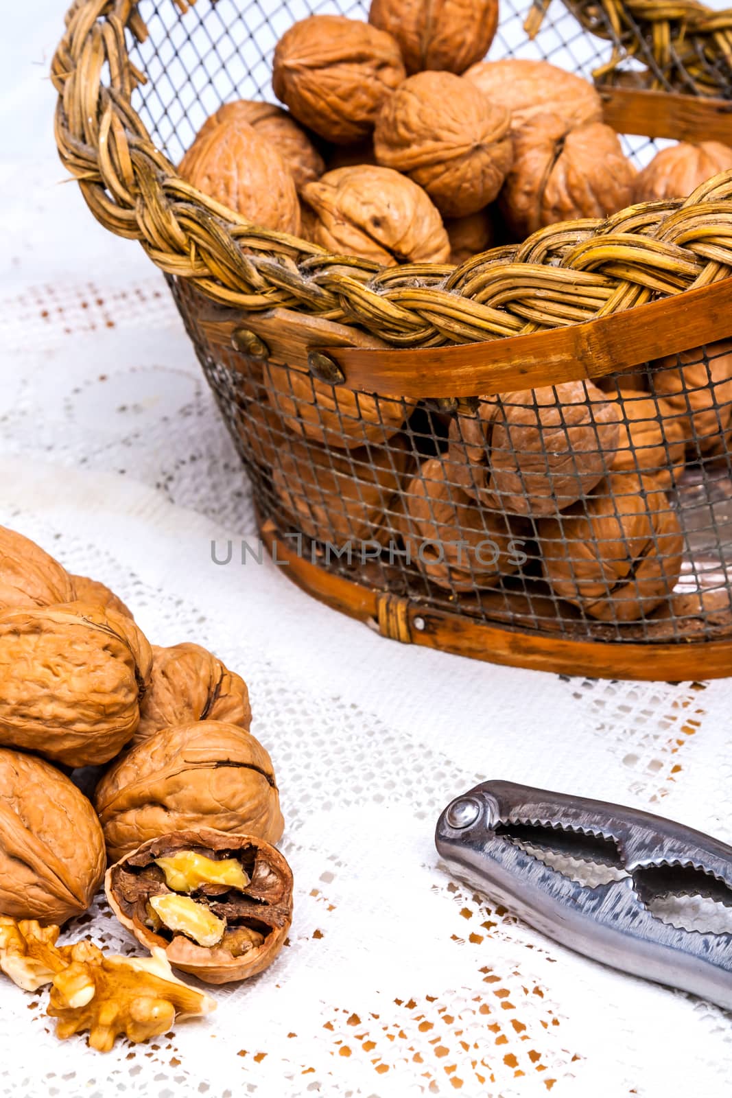 A composition of walnuts, cracked walnuts and a nutcraker