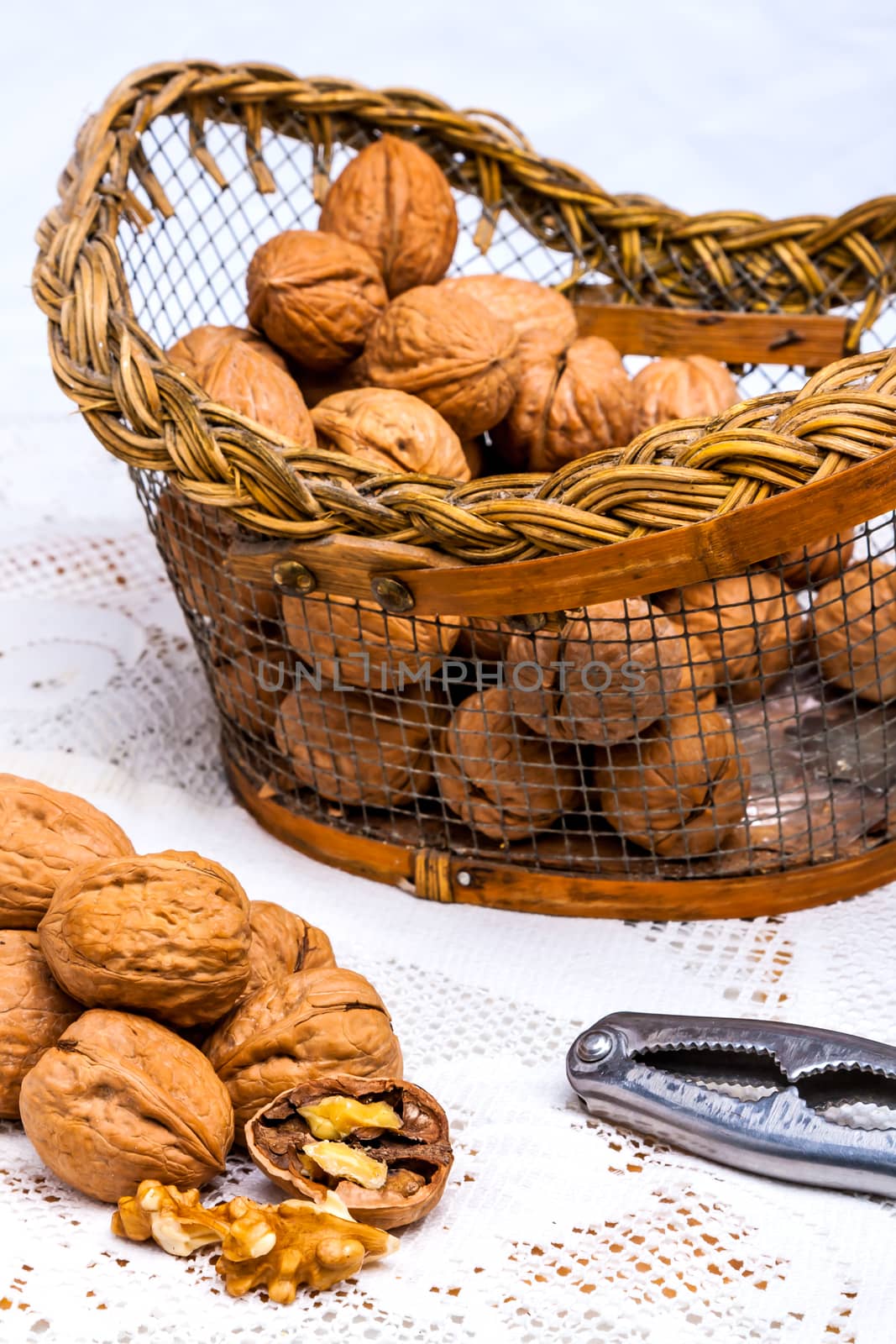 A composition of walnuts, cracked walnuts and a nutcraker
