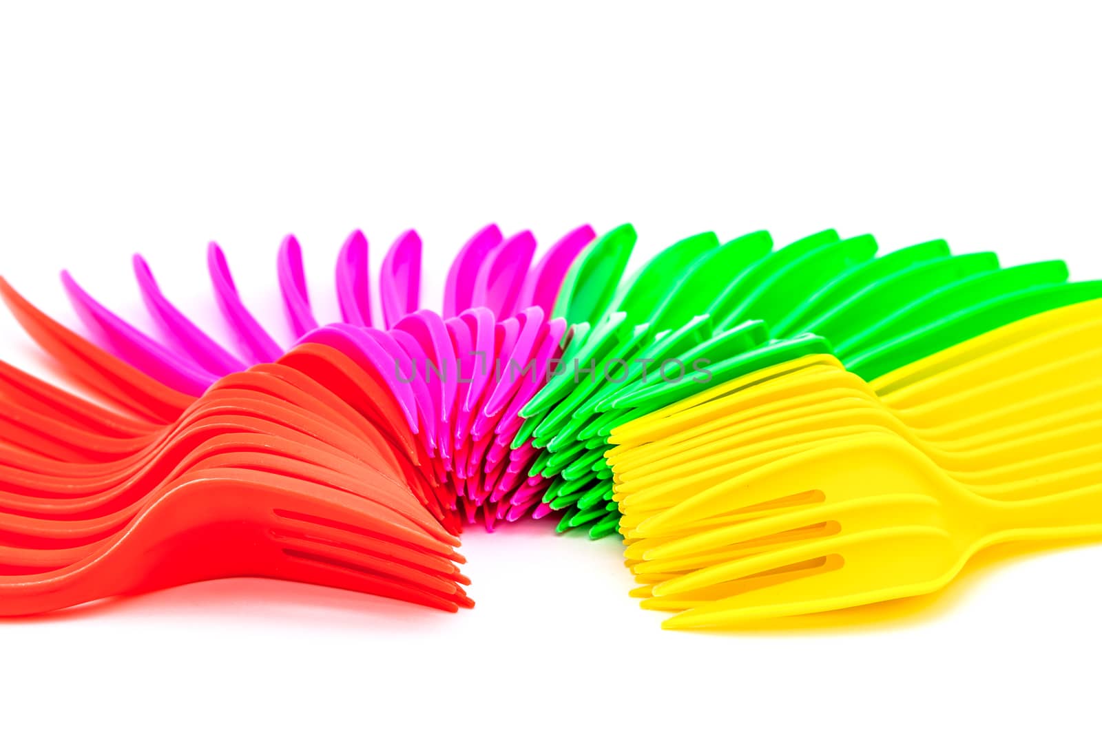 Multi colored plastic cutlery on a white background