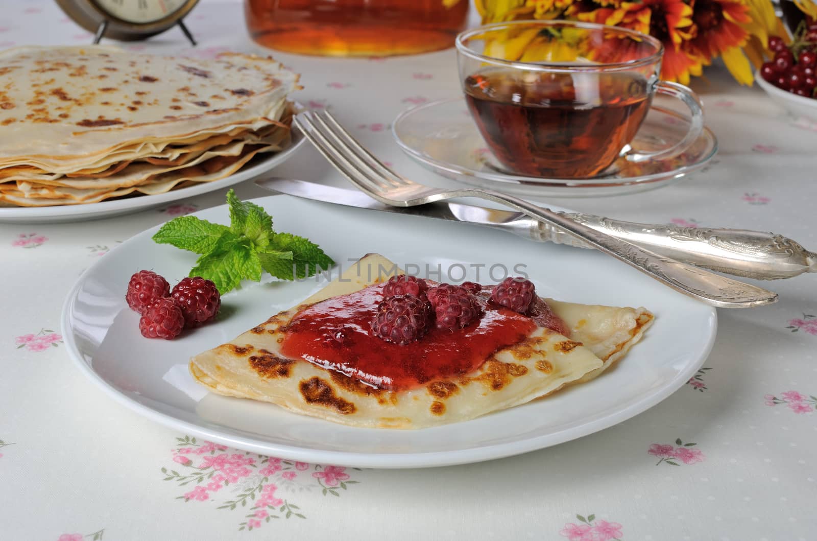 Pancakes with raspberry jam and berries