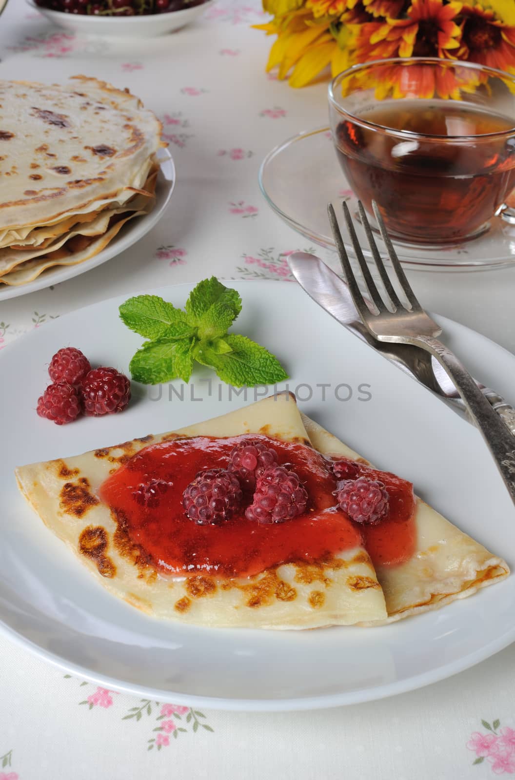 Pancakes with raspberry jam and berries