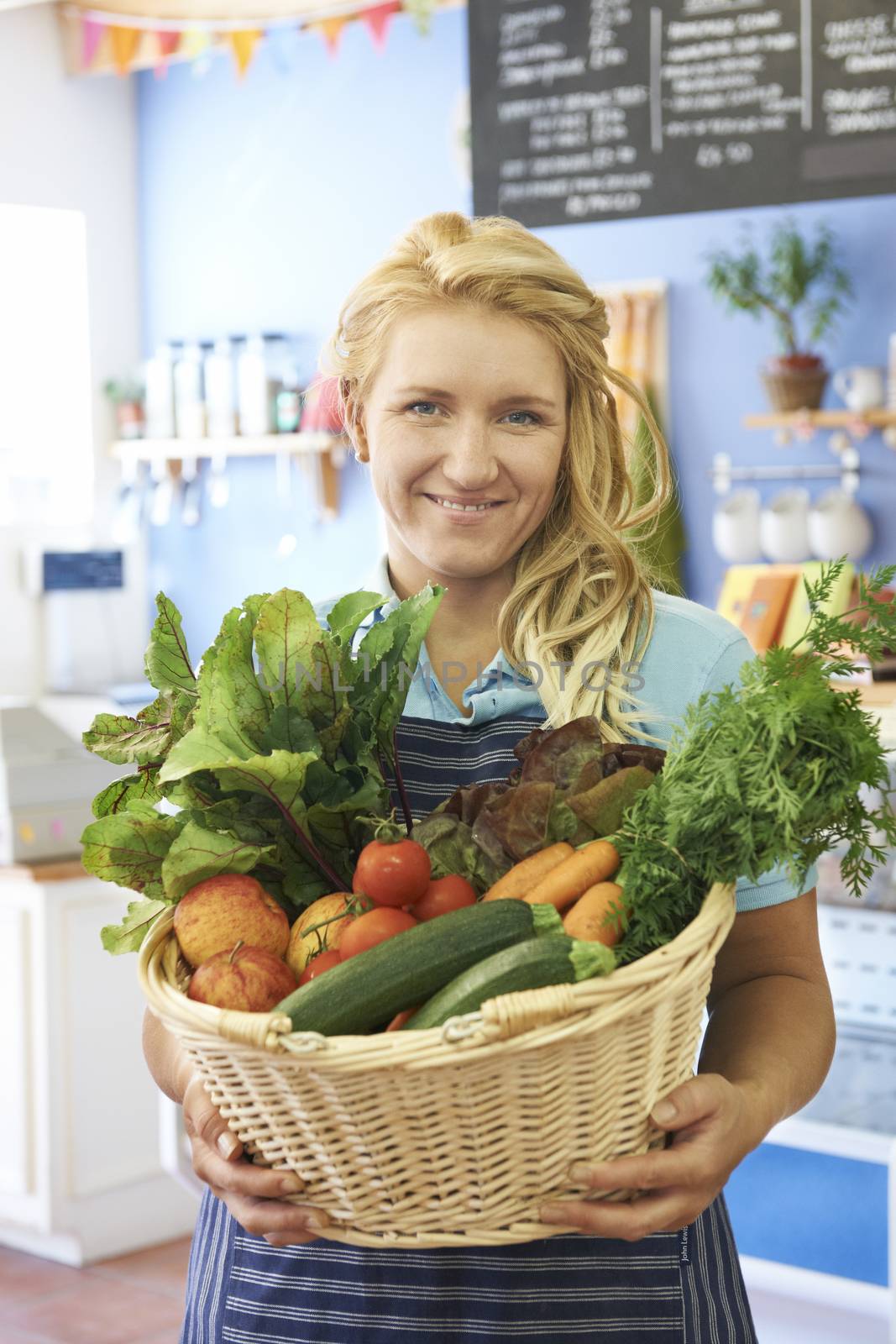 Woman Working In Shop With Basket Of Fresh Produce