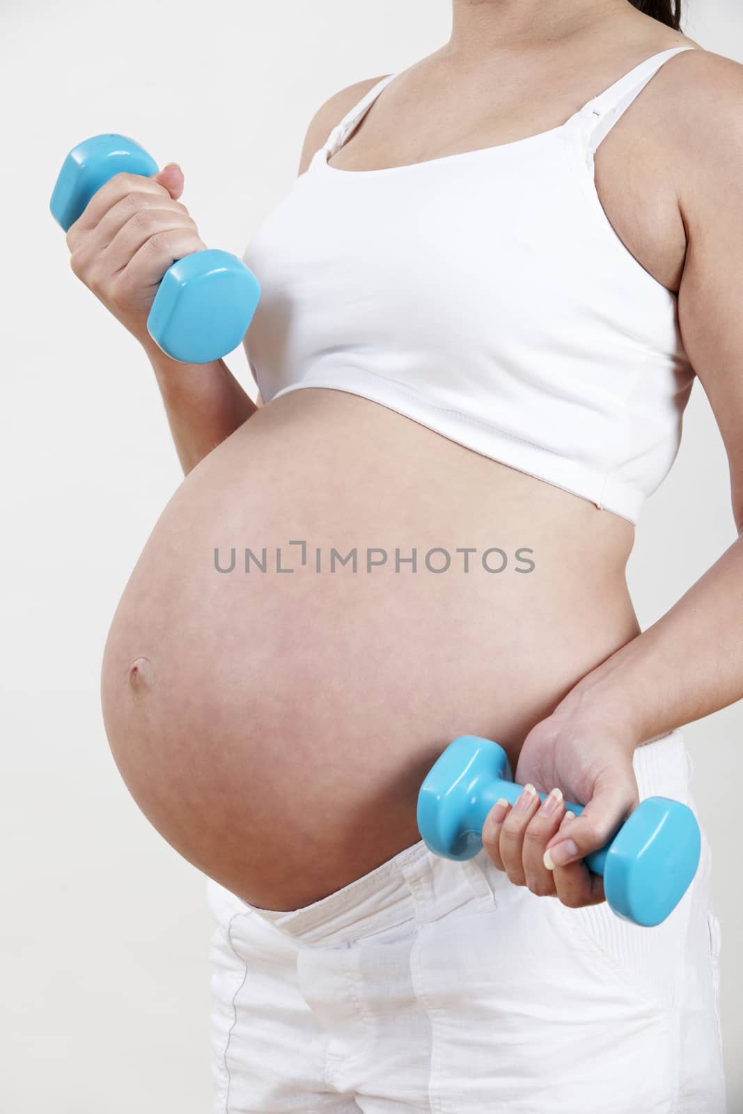 Close Up Of Pregnant Woman Exercising With Weights