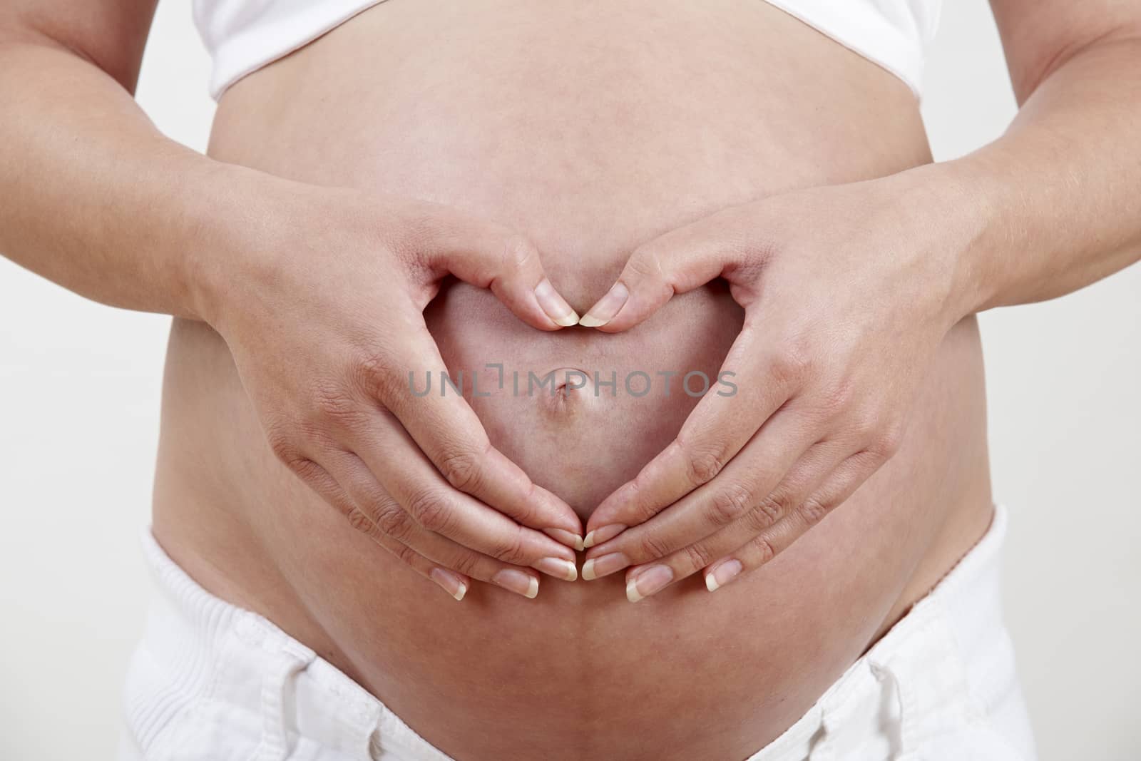 Pregnant Woman With Hands Forming Heart Shape