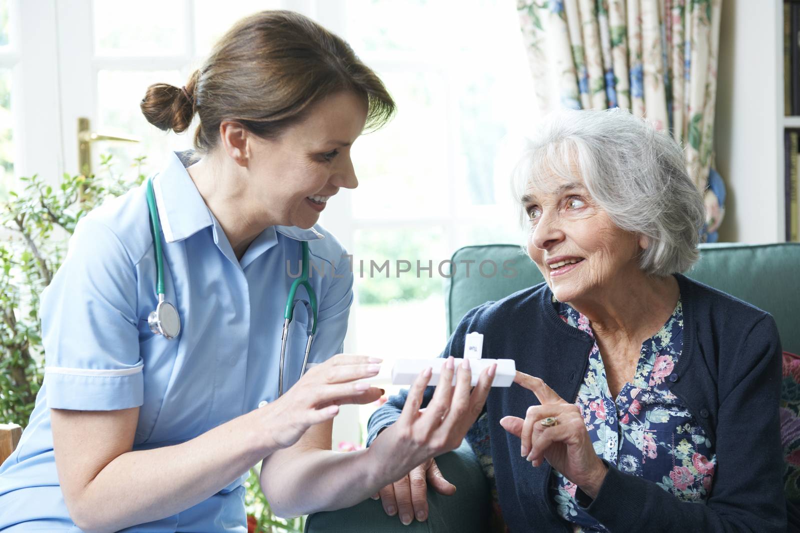 Nurse Advising Senior Woman On Medication At Home by HighwayStarz