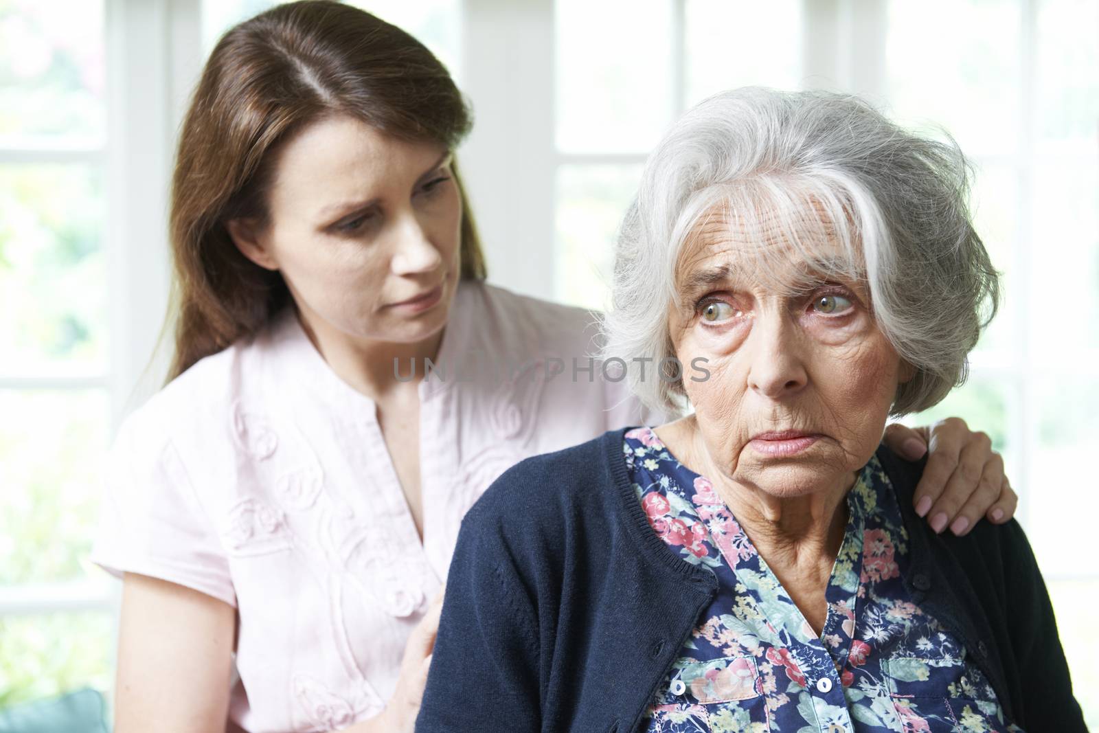 Adult Daughter Consoling Senior Mother At Home