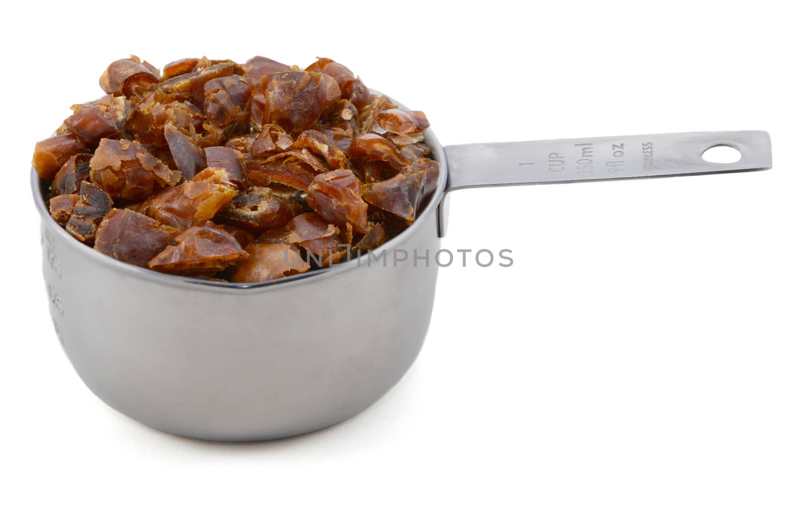 Chopped dates in an American cup measure, isolated on a white background