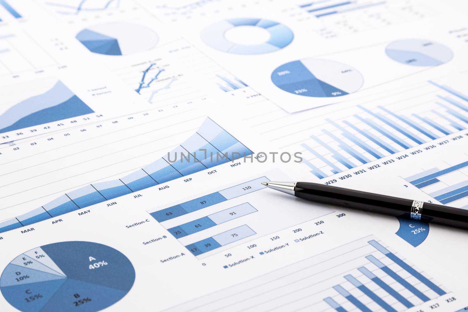 pen on blue charts, graphs, data and reports background for education and business concepts