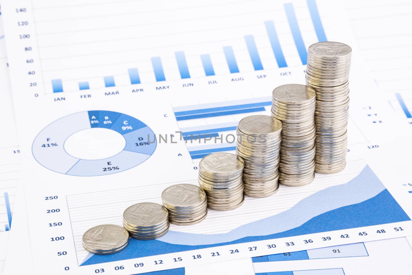 stacks of coins on  graphs and charts  by vinnstock