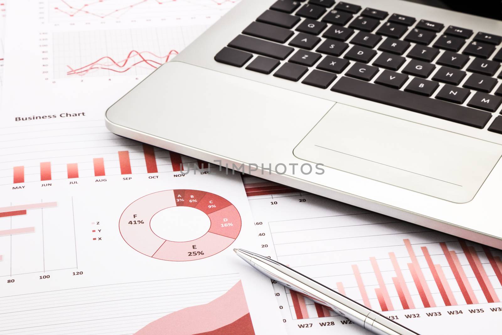 laptop and pen with red business charts, graphs, infomation and reports background for financial and business concepts