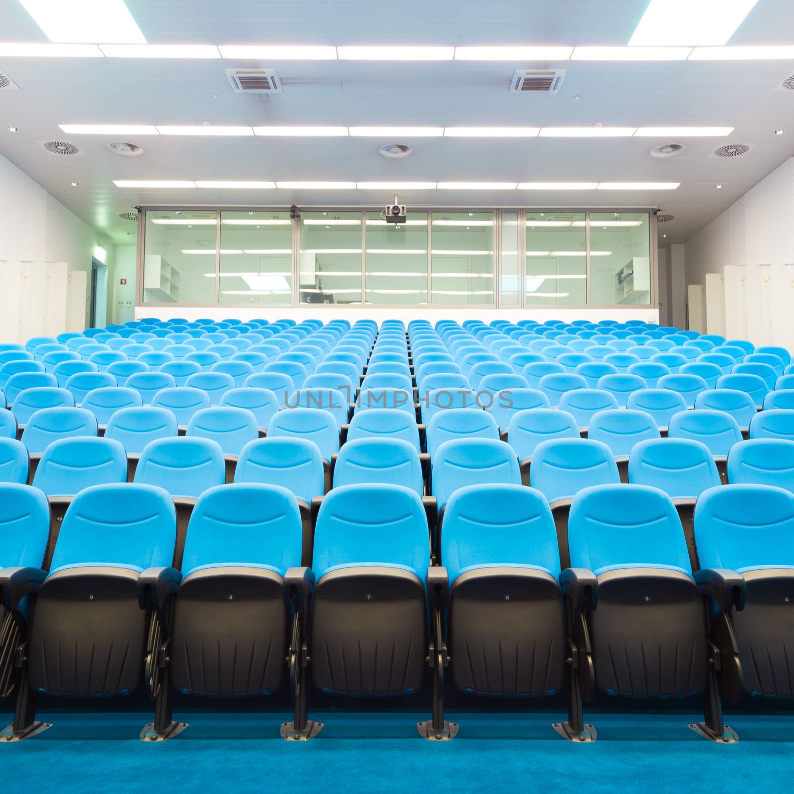 Interior of empty conference hall with blue velvet chairs.