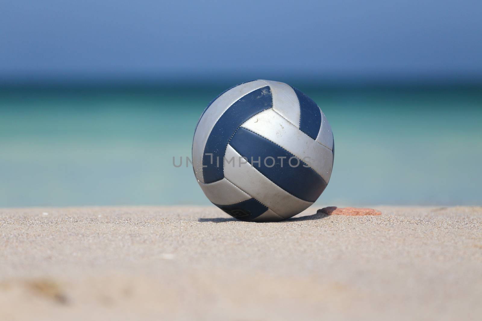  Close up of leather volleyball on  beach.