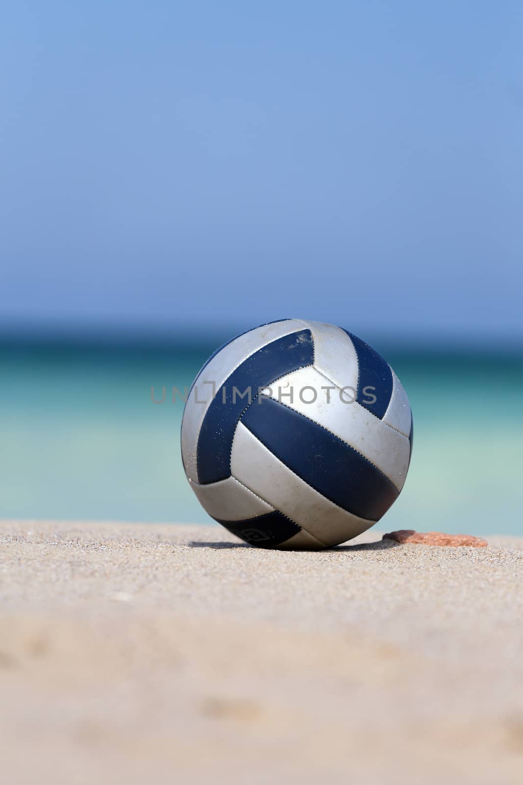  Close up of leather volleyball on  beach.
