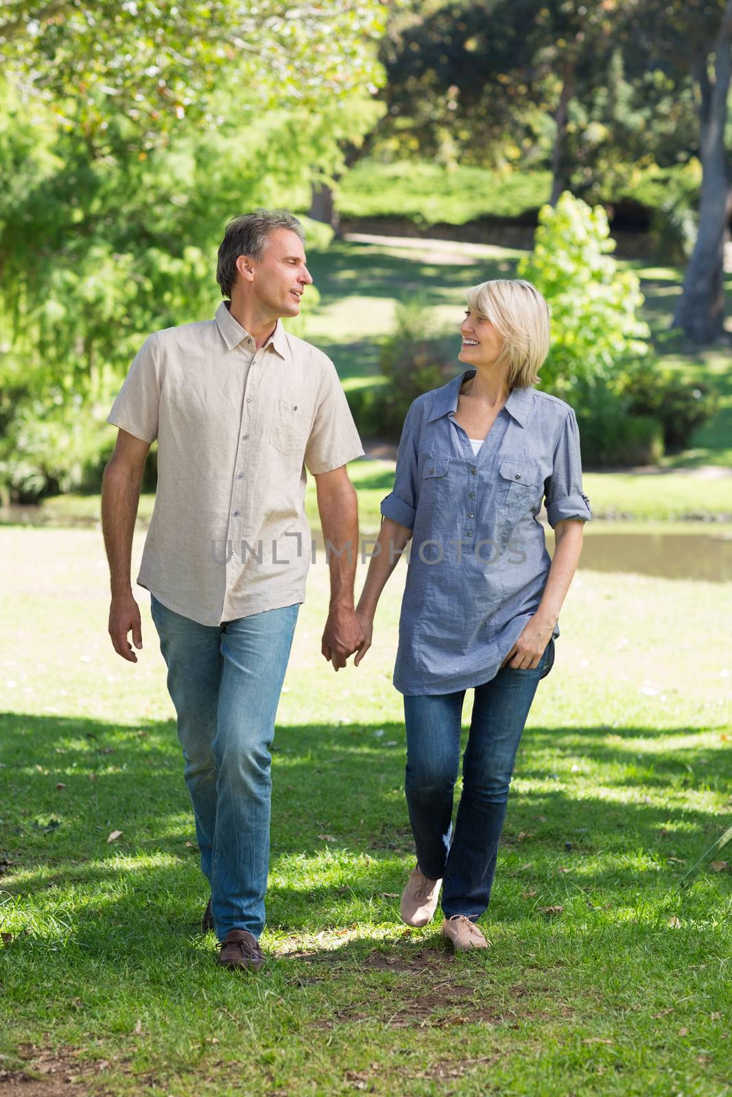 Full length of romantic couple walking together in park