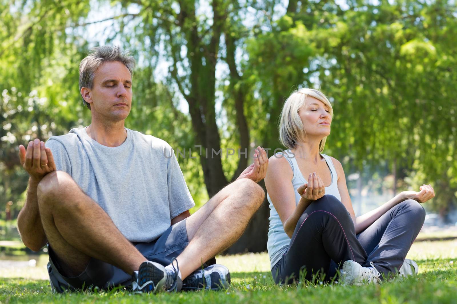 Couple sitting in lotus position by Wavebreakmedia