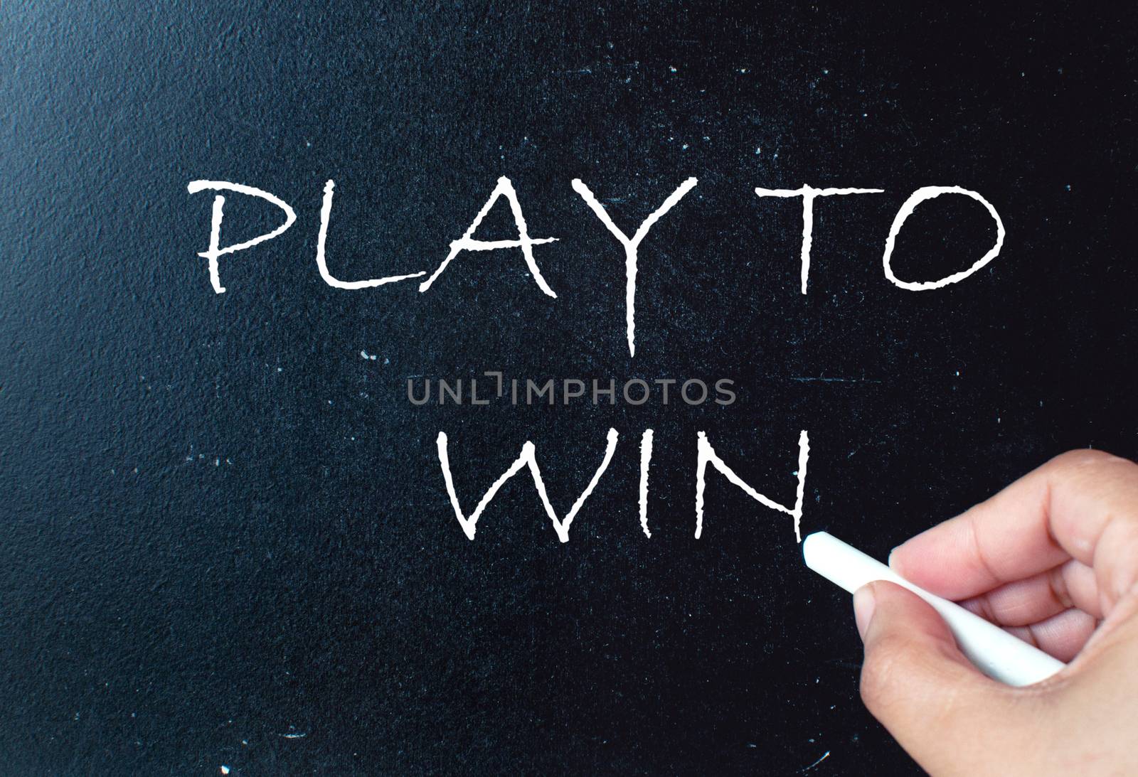 Play to win handwritten on a chalkboard