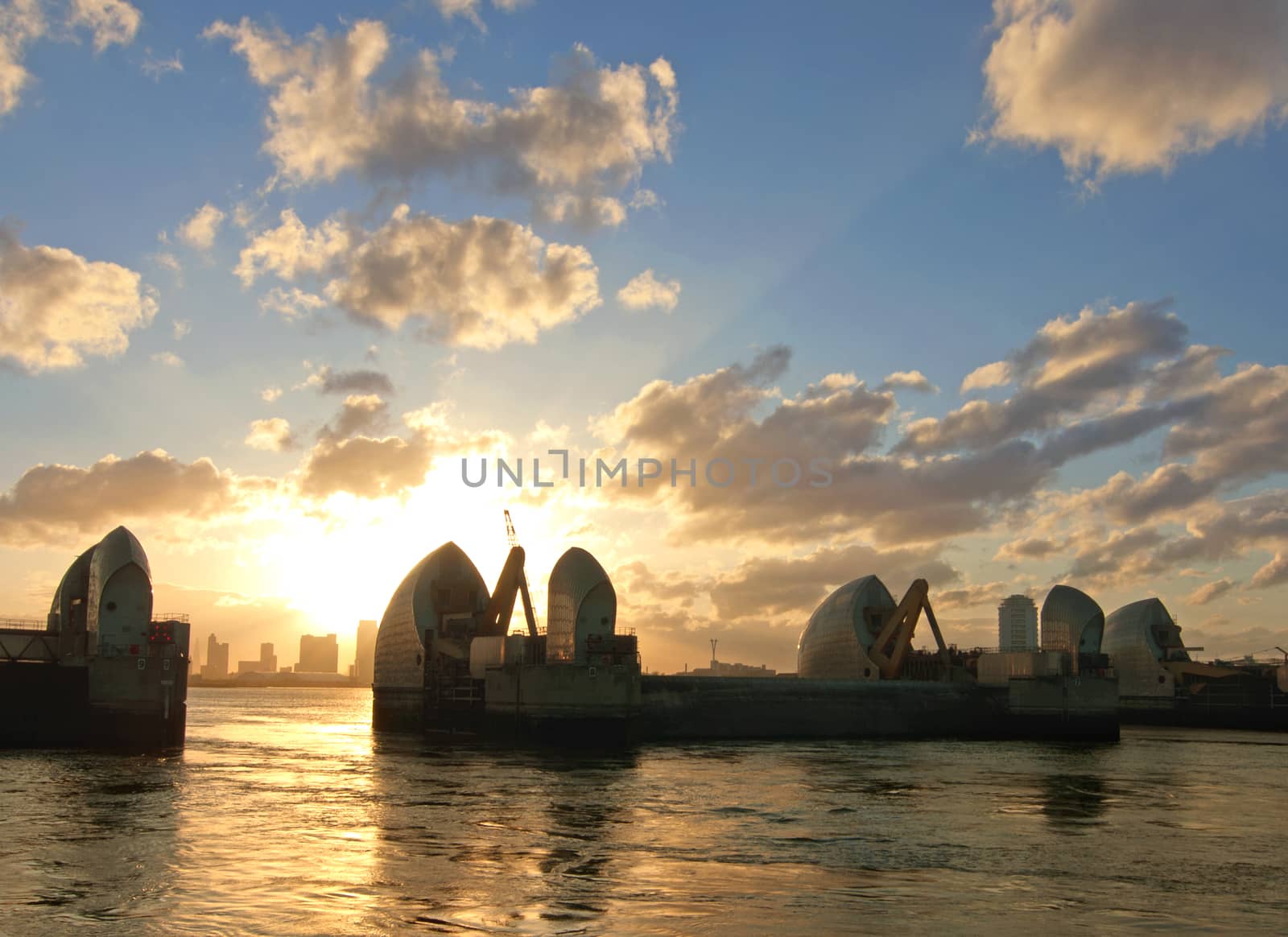 London River Thames barrier flood defenses with Canary Wharf skycrapers in the distance 