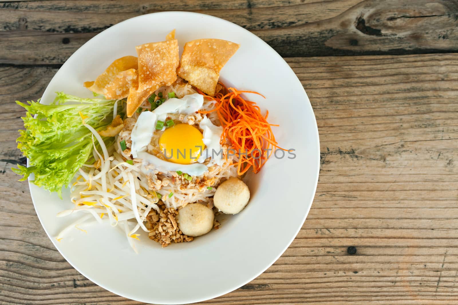 Gai pad bai gaprow style Thai dish with fried egg and rice noodles.