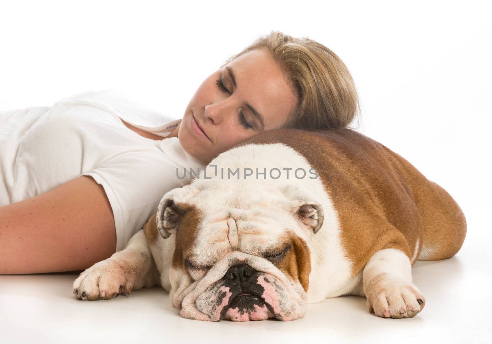 woman laying down with head resting on english bulldog