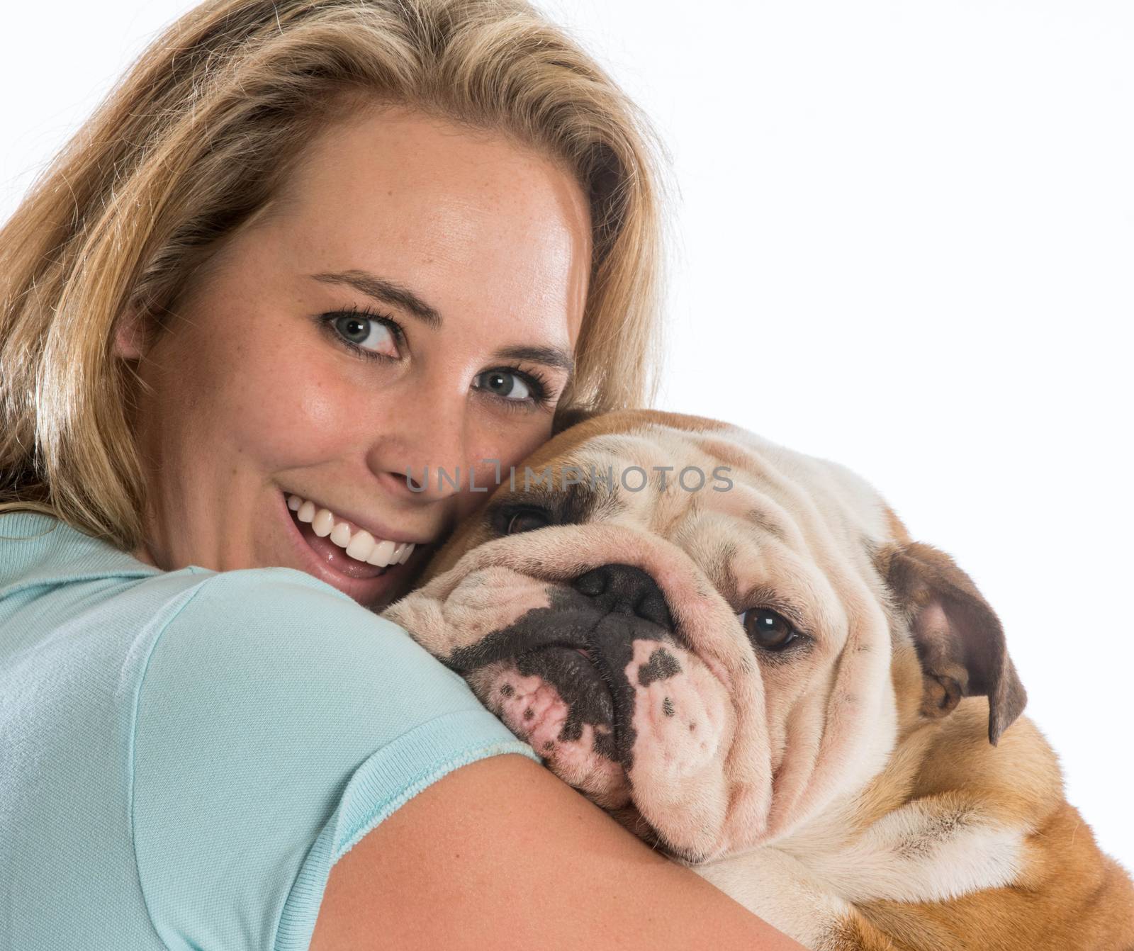 happy woman hugging her dog - english bulldog