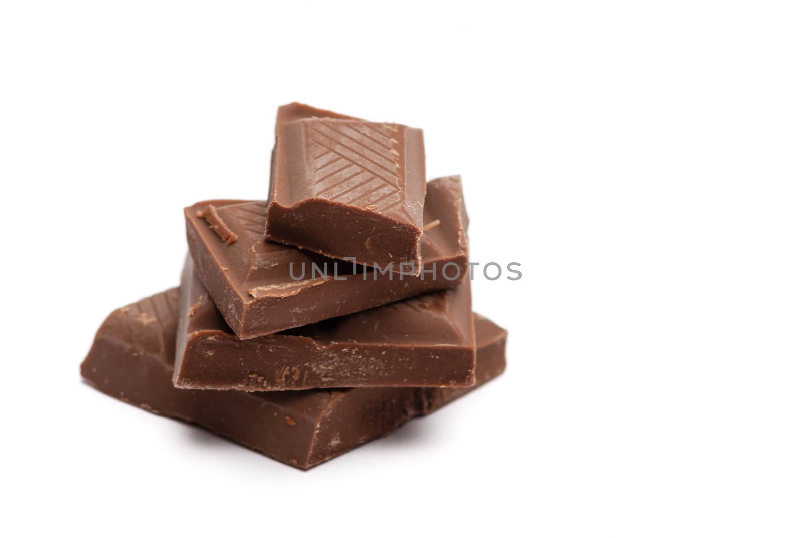 stack of dark chocolate pieces on white background