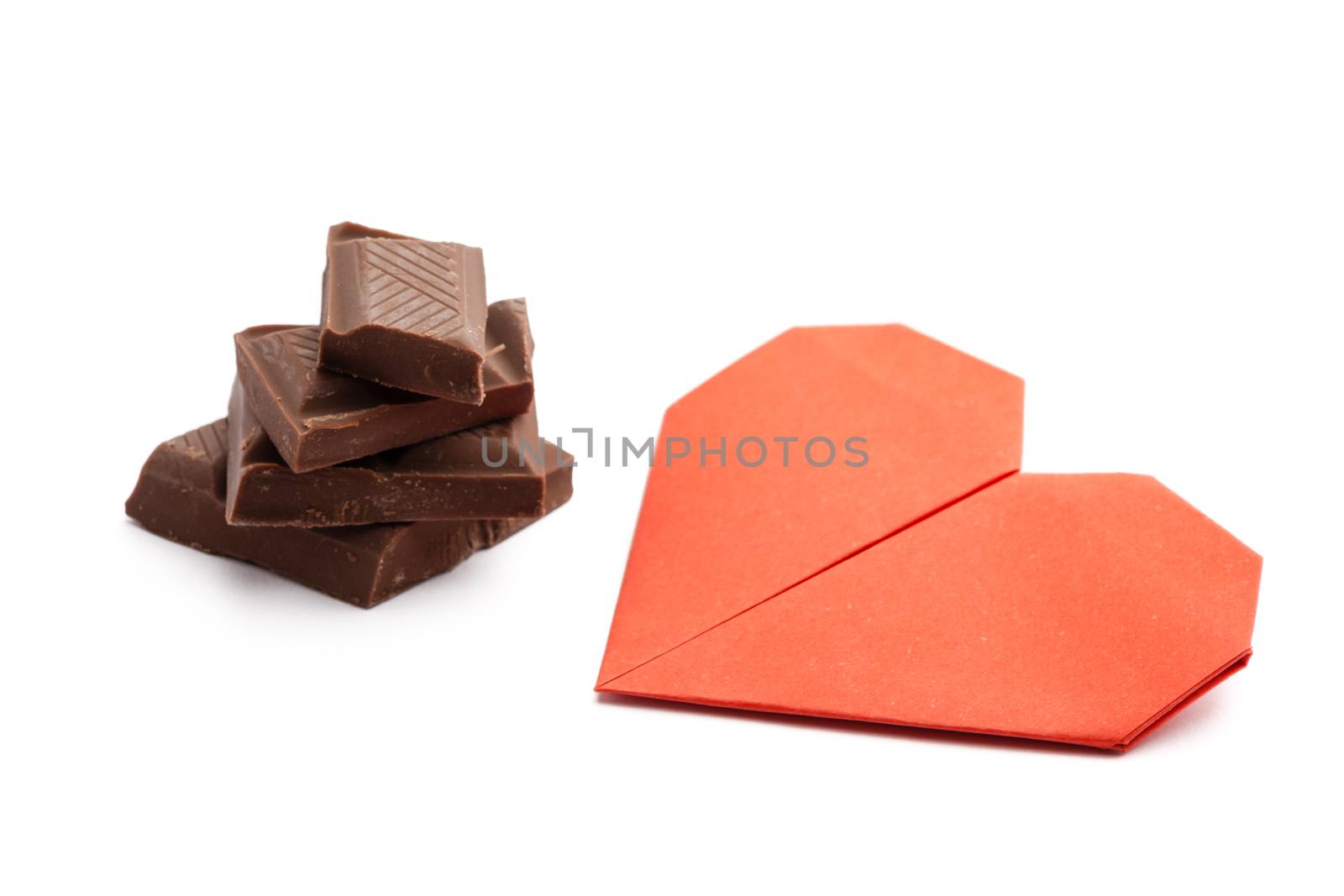 stack of dark chocolate pieces with red origami heart