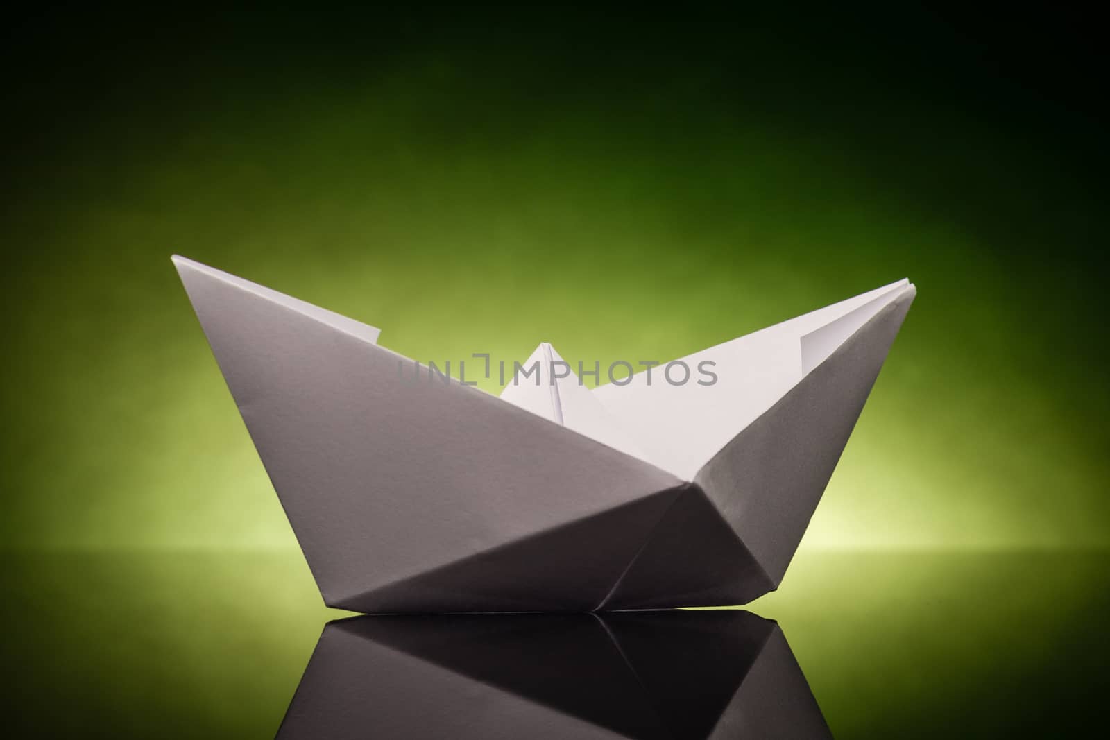 white origami paper boat with green back light