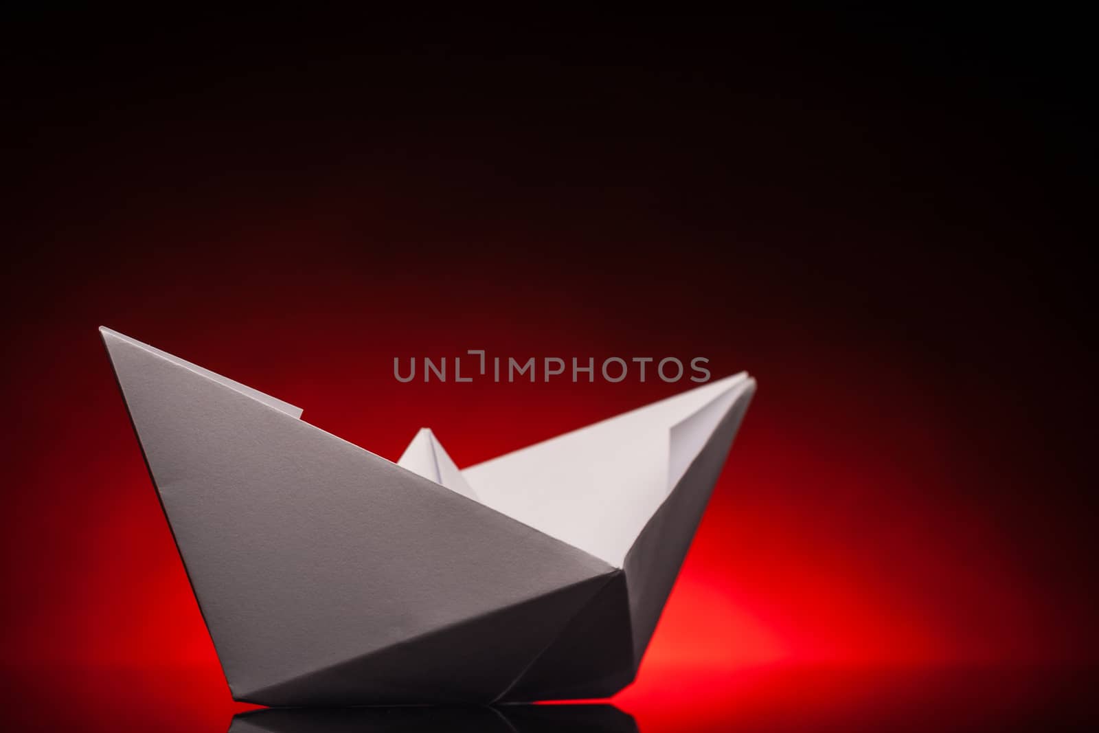white origami paper boat with red back light