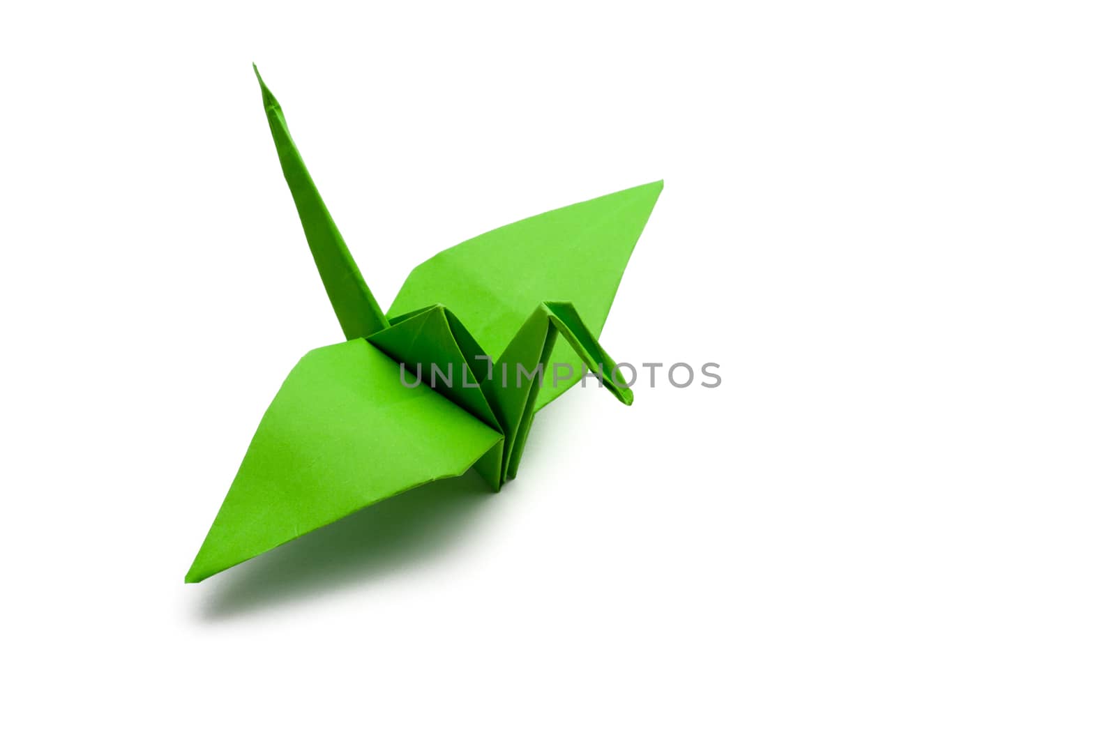 green origami paper crane on white paper background