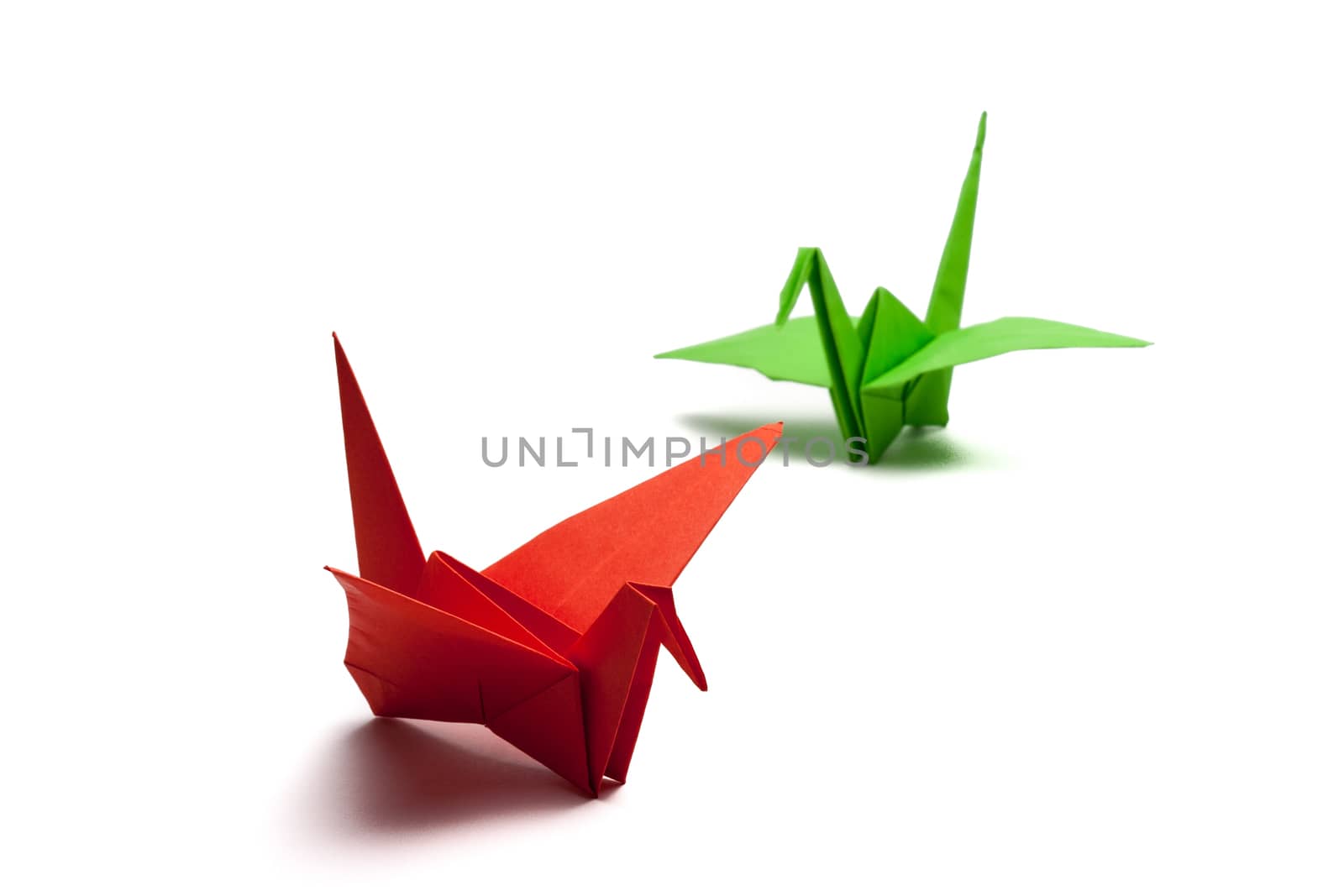 red and green origami paper crane on white paper