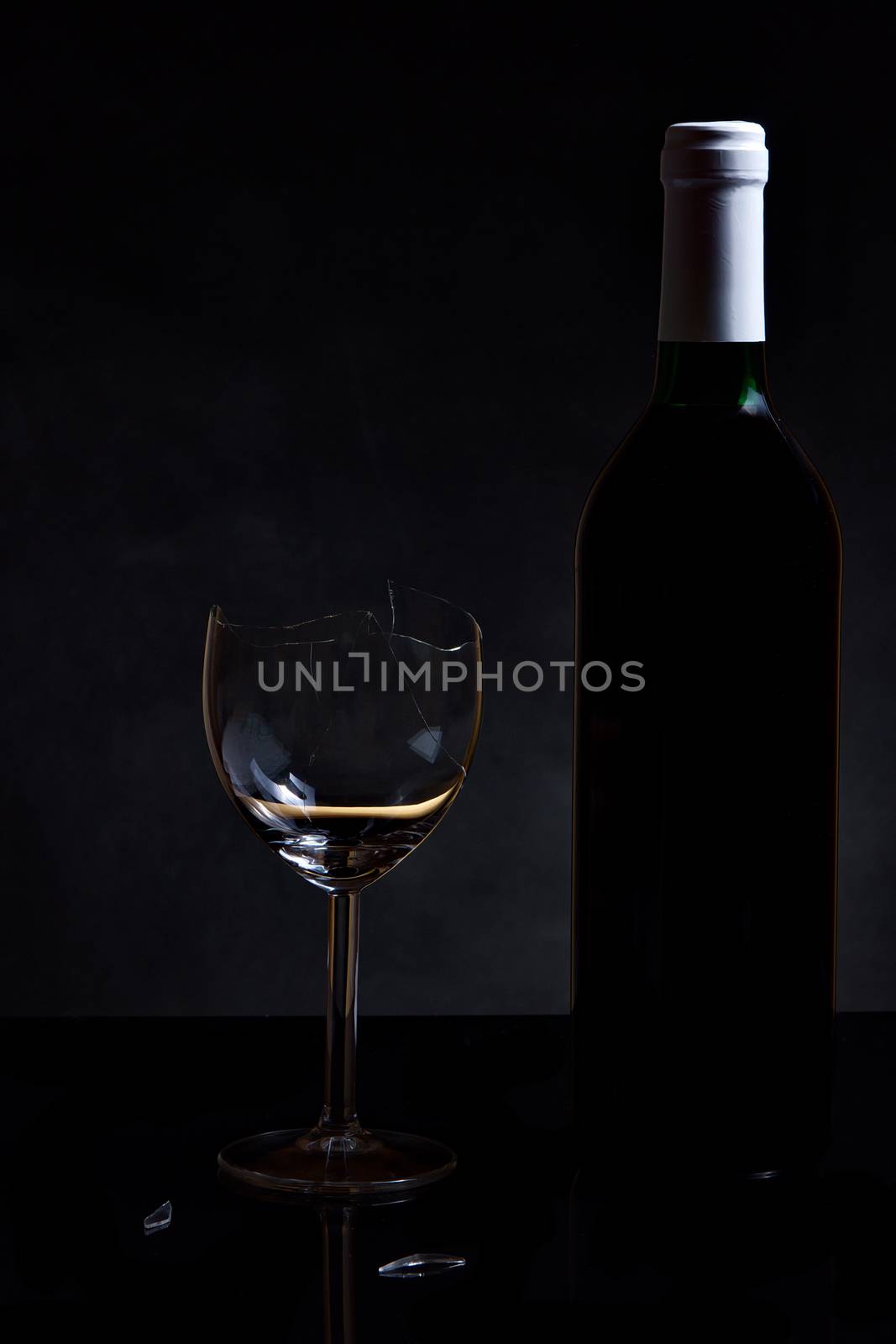 Vine bottle and broken glass on dark background