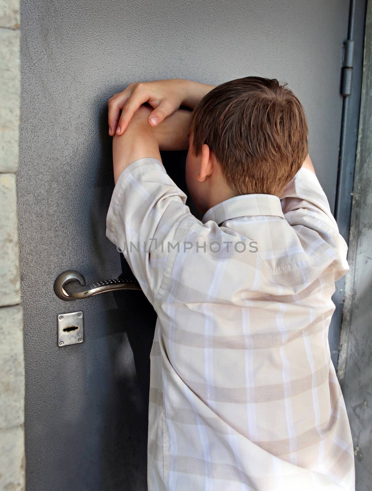 Sad Kid in front of Closed Door