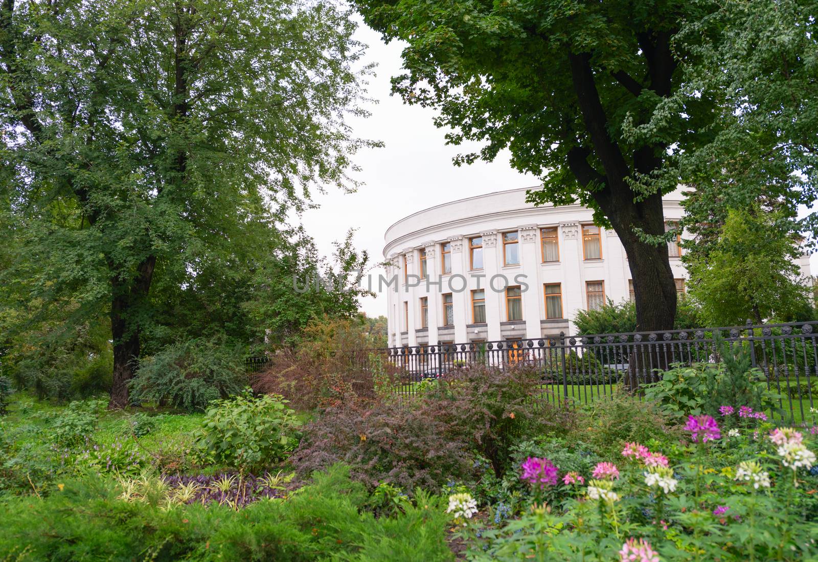 Parliament of Ukraine (Verkhovna Rada) in Kiev, Ukraine view from green plants and flowers in park.