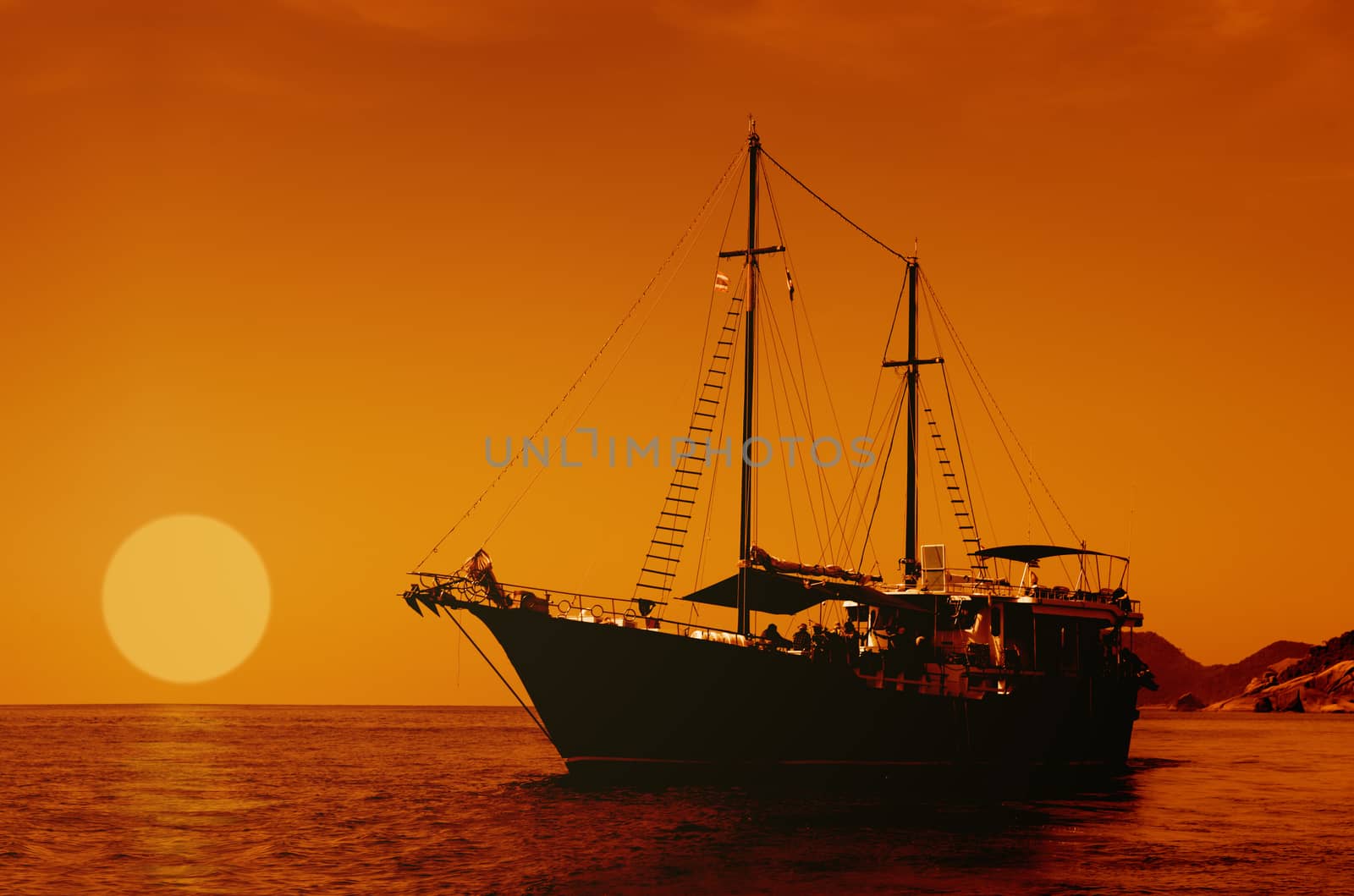 Sailing ship silhouette on the sea at sunset skyline. 