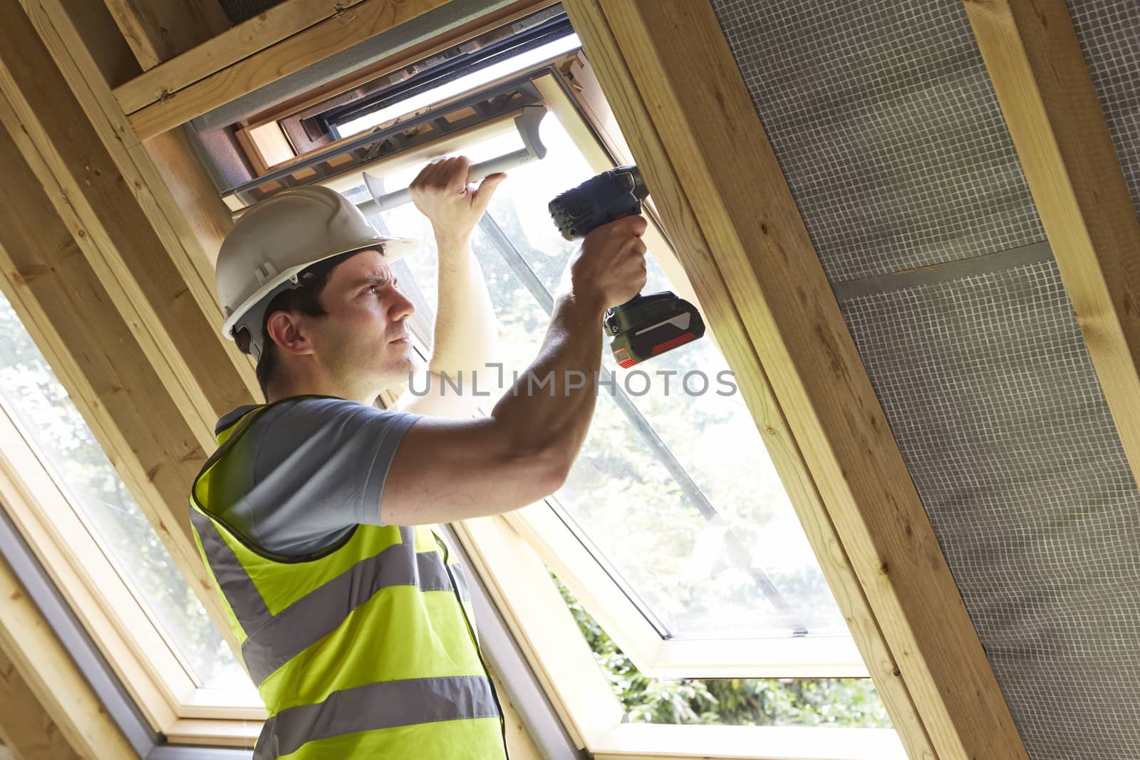 Construction Worker Using Drill To Install Window by HighwayStarz