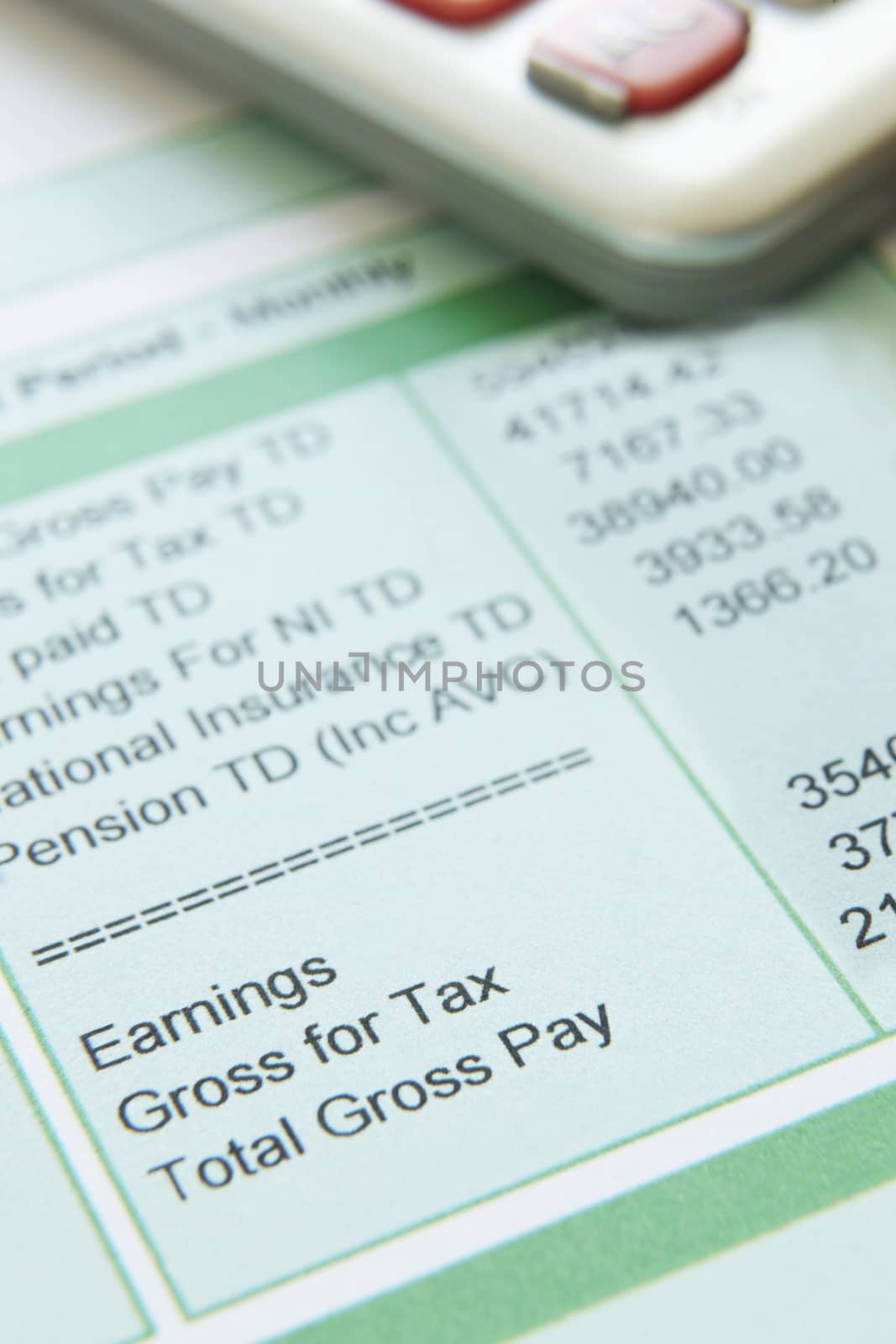 Close Up Of Pay Slip With Calculator