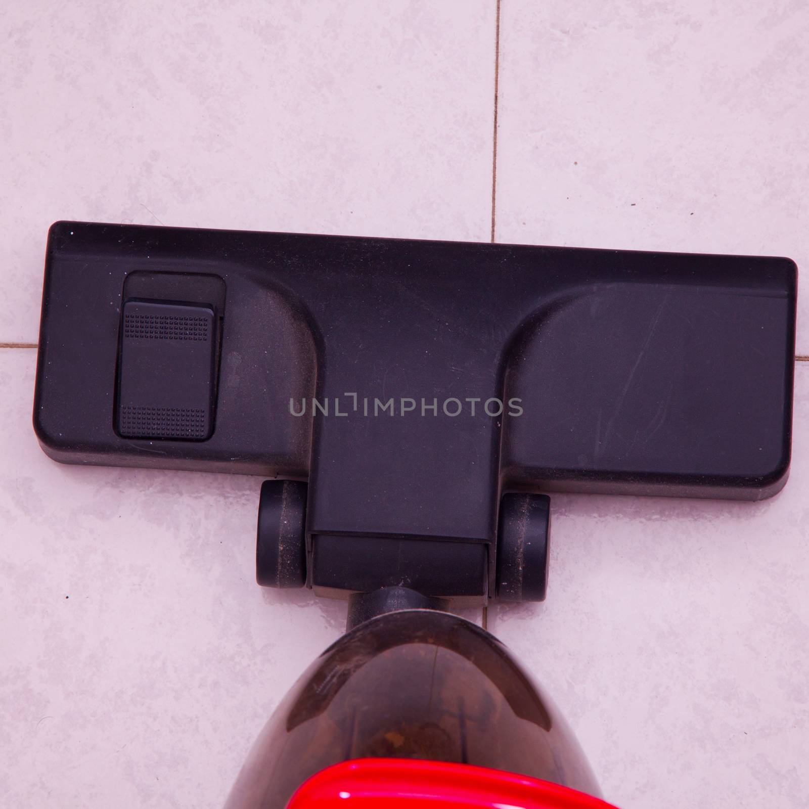 Red vacuum cleaner working over floor, seen from above