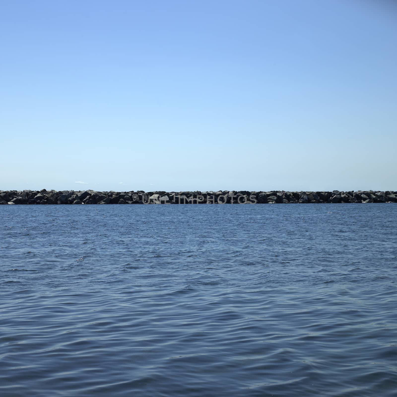 Large stone wall on a blue lake