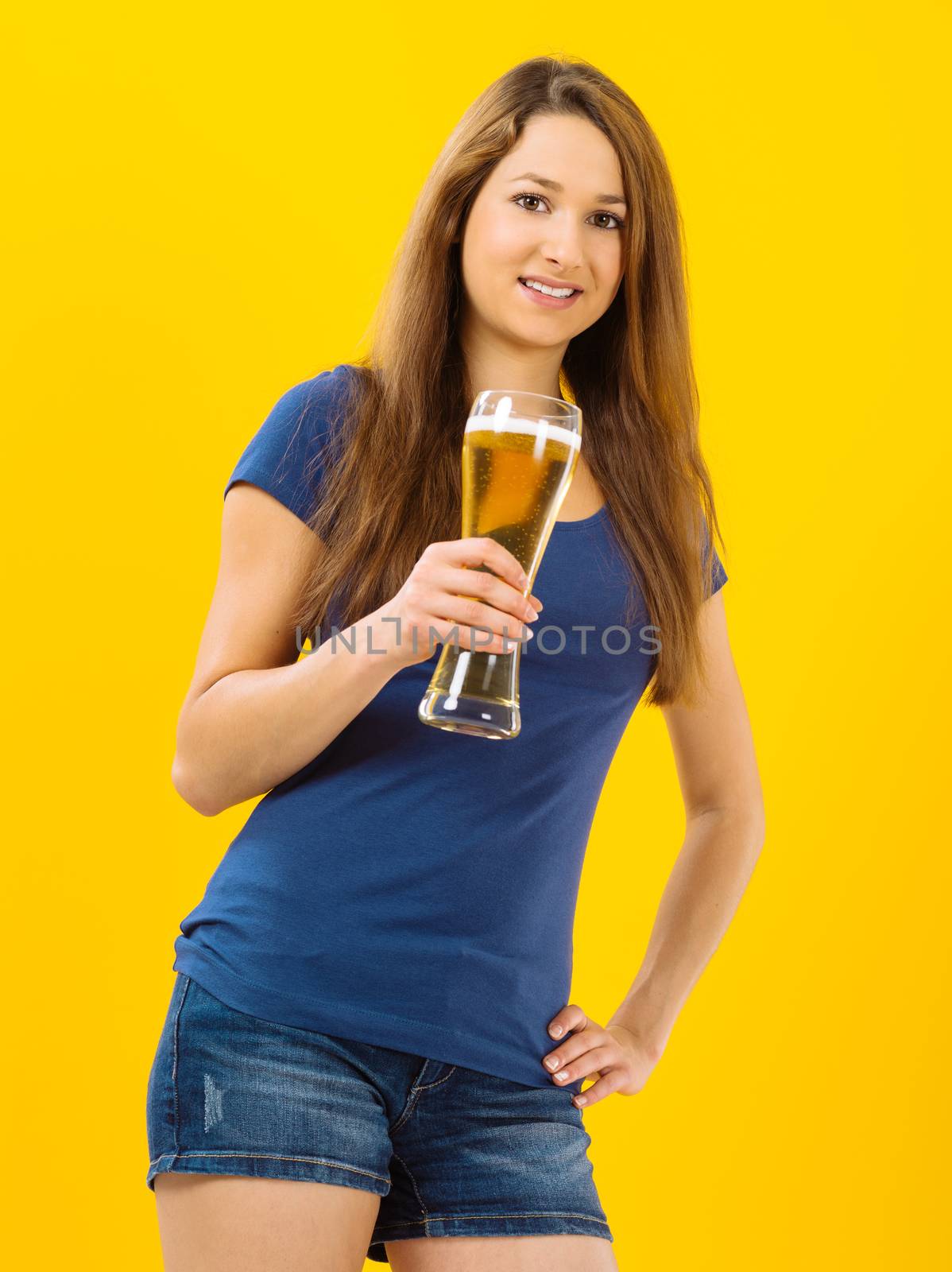 Smiling young woman drinking beer by sumners