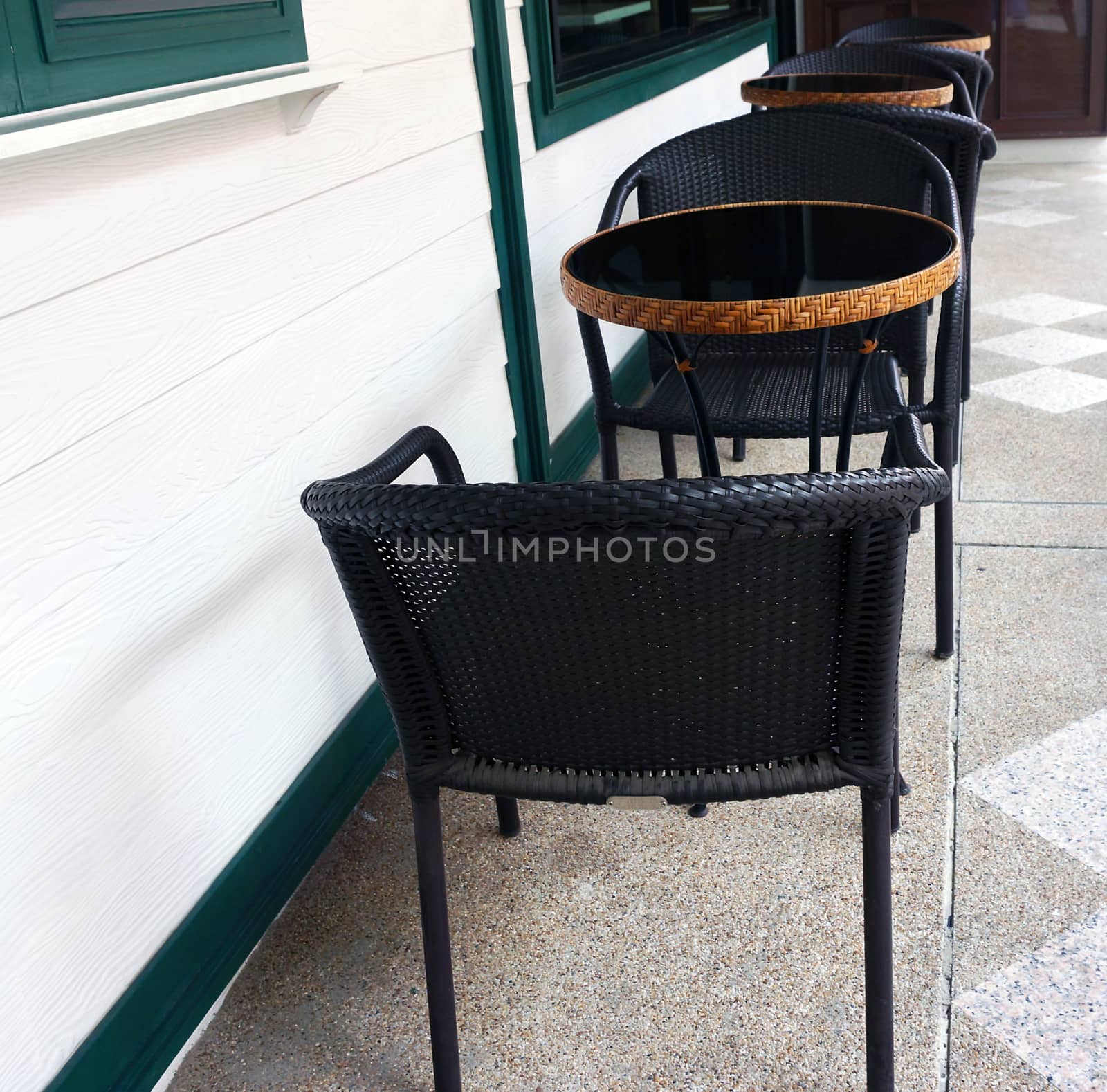 Tables and chairs placed on the outside of the coffee shop.                               