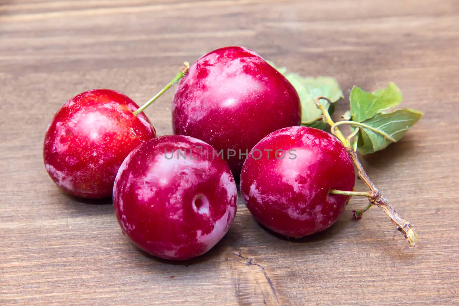 Fresh plums on wooden table