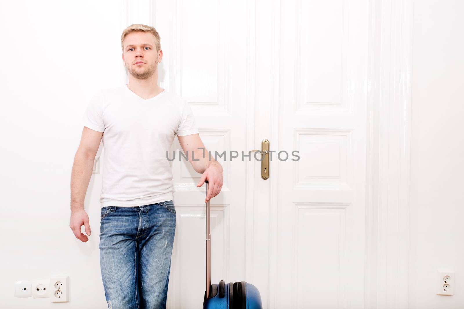 A young man going to travel with a suitcase.