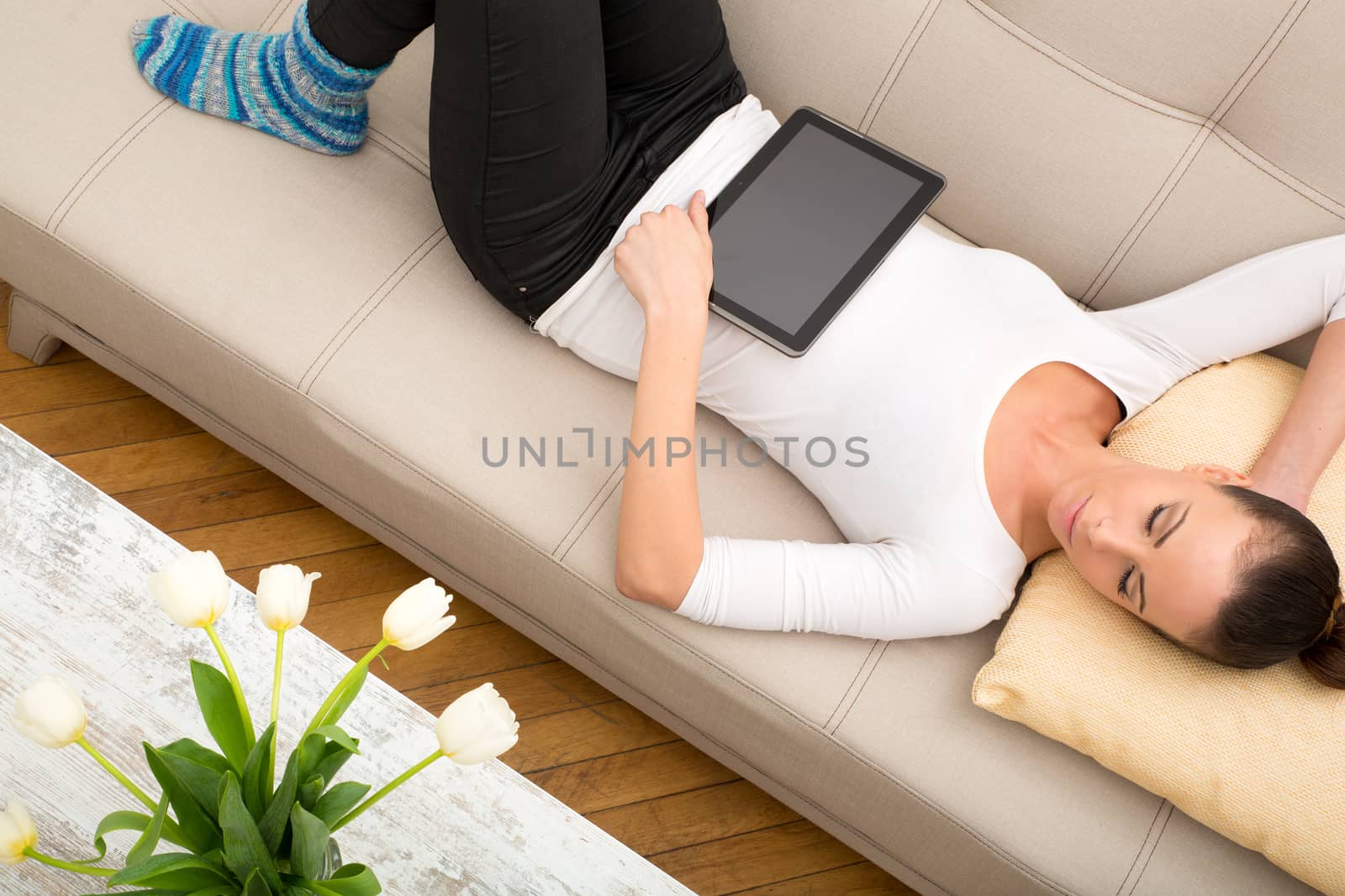 A young woman with a tablet pc on the sofa.