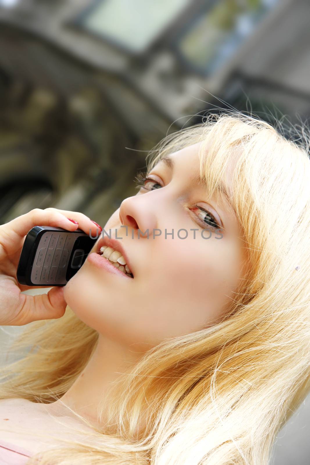 A young adult woman talking on the phone.