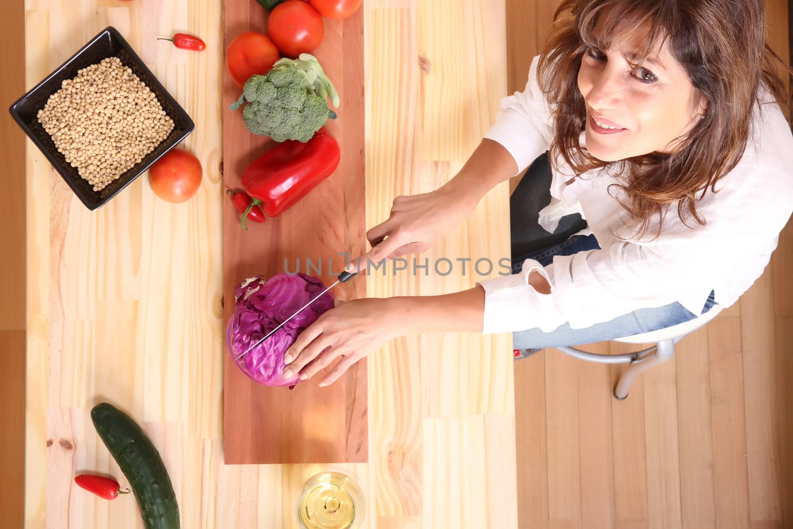 A beautiful mature woman cutting vegetables in the kitchen.