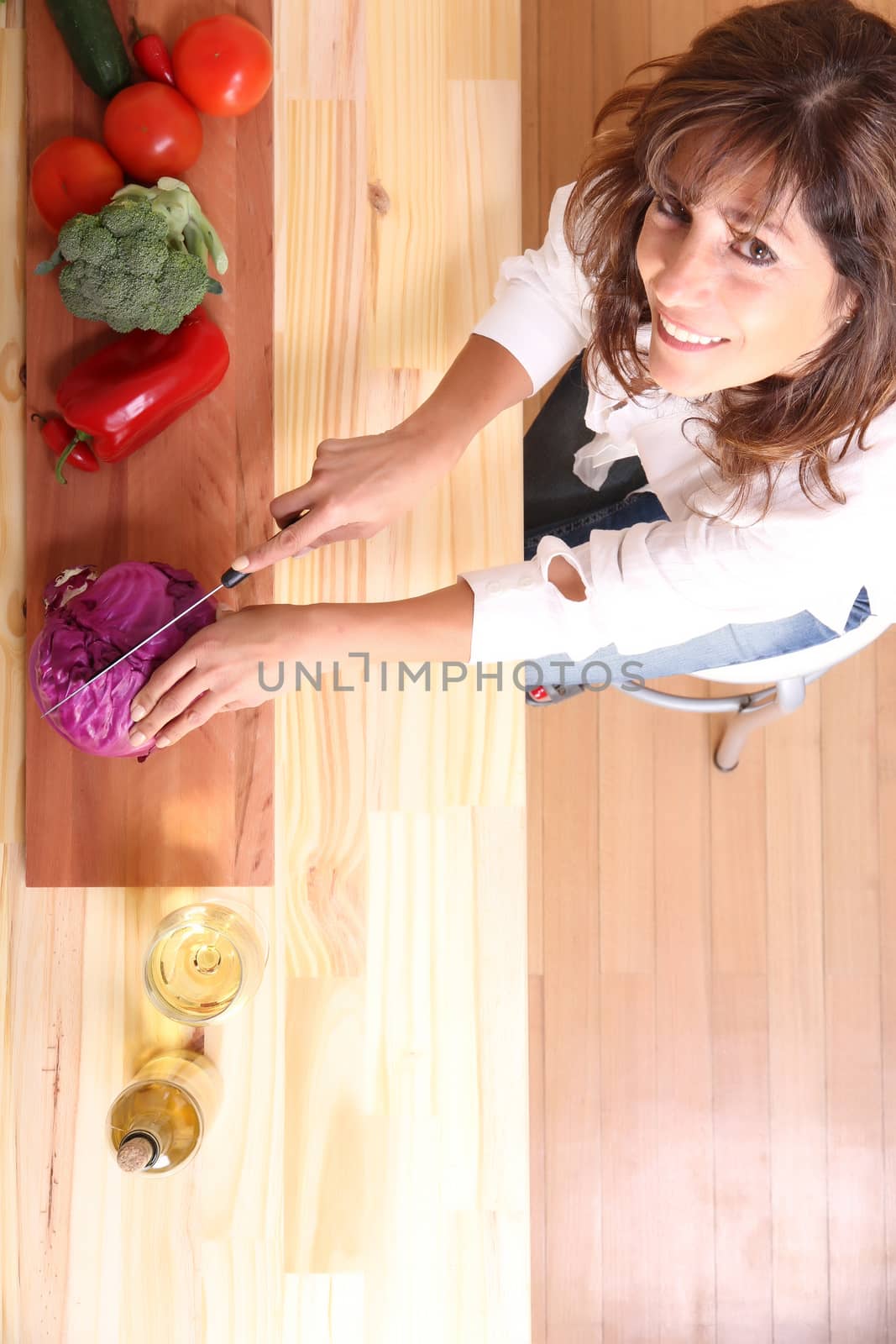 A beautiful mature woman cutting vegetables in the kitchen.