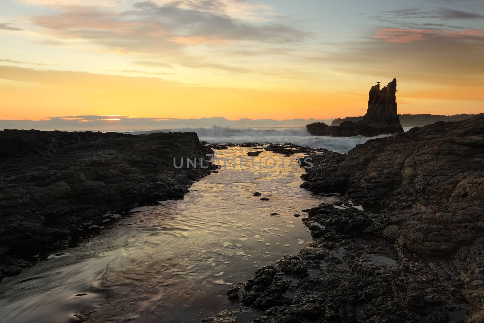 Waves crashing around Cathedral Rock at sunrise, south coast, NSW, Australia