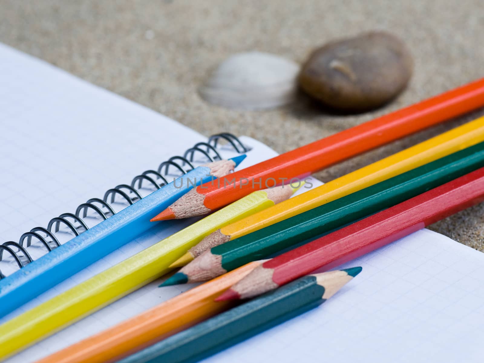 school supplies pencils colors on the beach
