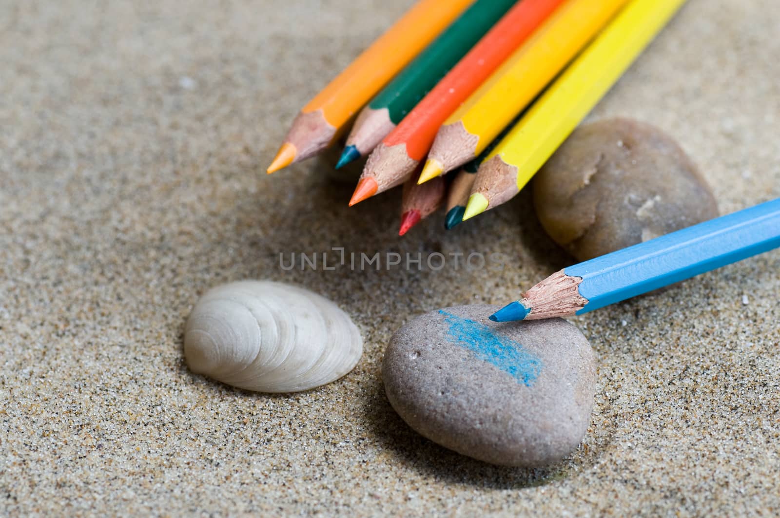 school supplies pencils colors on the beach